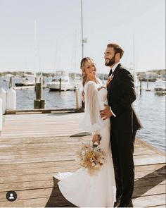 a bride and groom standing on a dock