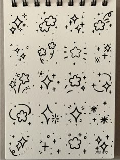 a white notebook with black ink on it and stars, clouds, and moon designs