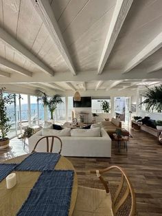 a living room filled with lots of furniture next to a large open floor plan and ocean view