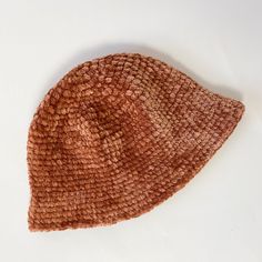 a brown knitted hat laying on top of a white table