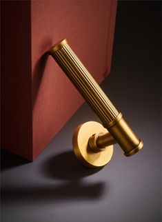 a close up of a door handle on a red and gold wall mounted light fixture