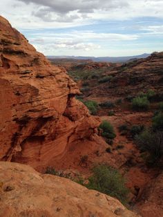a person standing on top of a large rock formation in the middle of a desert