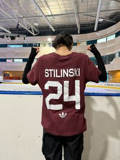 a man standing in front of a wall wearing a shirt with the number twenty on it