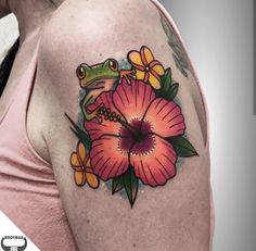 a woman with a frog and flower tattoo on her shoulder