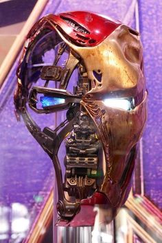 a close up of a helmet on display in a room with purple walls and lights