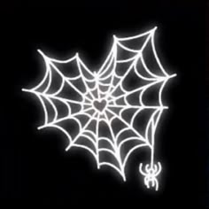 a spider web on a black background with white lights in the center and an orange spider hanging from it's side