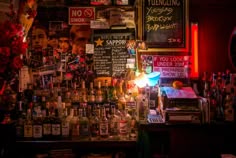 a bar with lots of liquor bottles and signs on the wall