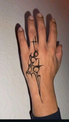 a person's hand with a cross tattoo on it