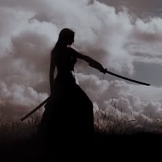 a woman holding two swords in front of clouds