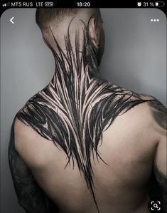 the back of a man's neck with black feathers on it