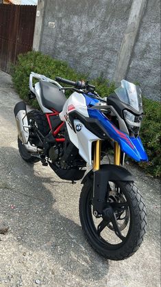 a blue and white motorcycle parked in front of a building