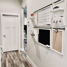 a white wall with multiple pictures hanging on it's side and a door in the background