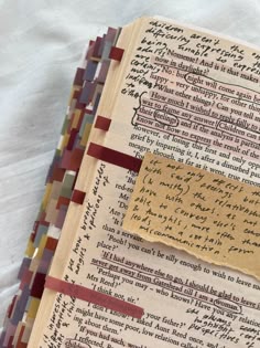 an old book with writing on it and some papers taped to the pages that have been altered