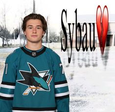 a young man standing in front of a sign with the name syqua on it