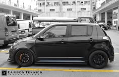 a small black car parked in a parking lot