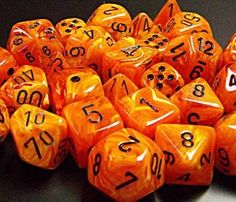 orange and black dice with numbers on them sitting on top of a table next to each other