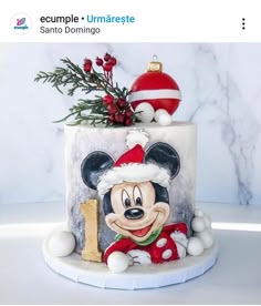 a decorated cake with a mickey mouse on it's side and a christmas ornament hanging from the top