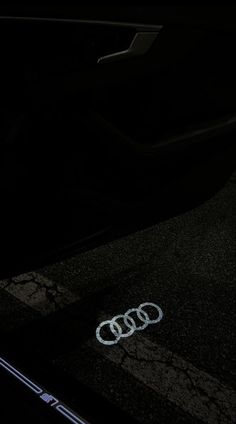 an audi logo is shown on the floor of a car in the dark at night