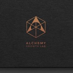 the alchemy growth lab logo is shown on a black surface with copper foil