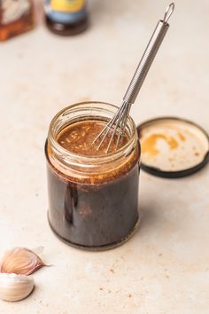 a jar filled with peanut butter next to garlic