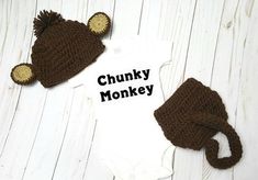 there is a baby hat and diaper cover on the white wooden floor next to it