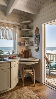 the inside of a beach house with an open door leading out to the ocean and a surfboard hanging on the wall