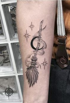 a woman's arm with a tattoo on it that has an arrow and feather