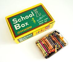 a box of crayons and a tin of colored pencils on a white surface
