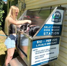 a woman standing next to a dog wash station