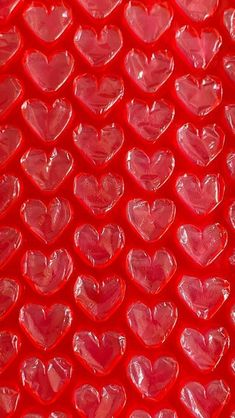 many red hearts are arranged in the shape of heart shapes on a bright red background
