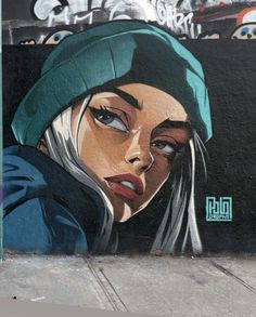 a painting on the side of a building with a woman's face painted on it