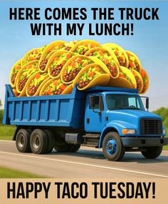 a blue truck with tacos on the back driving down a road