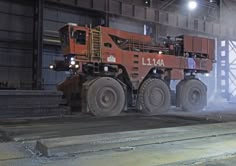 a large truck driving through a factory filled with lots of machinery