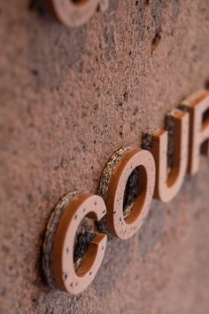 a close up of the word cofo written in wood letters on a stone wall