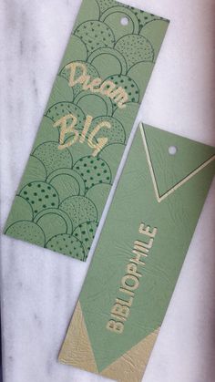 two green tags sitting on top of a table