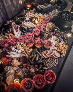 a table topped with lots of different types of food and candles next to each other