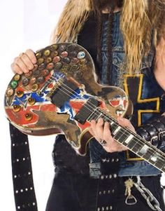 a man with long hair holding a guitar