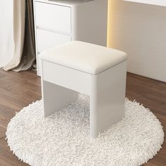 a white stool sitting on top of a wooden floor next to a desk and chair