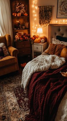 a bedroom decorated for fall with pumpkins and lights