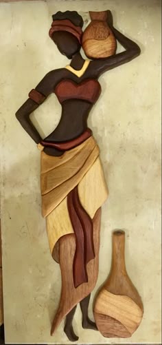 a wooden carving of a woman with two vases on the wall next to it