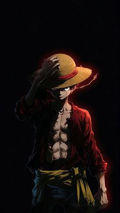 a man wearing a straw hat and holding his hands to his face while standing in the dark