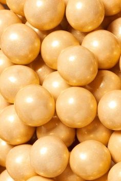 a close up view of some white chocolate balls with gold luster coatings on them