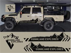 an off - road vehicle parked in a garage with mountains and trees decals on the side