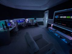 a living room filled with furniture and computer monitors