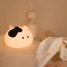 a night light with a cow face on it sitting on a table next to a teddy bear