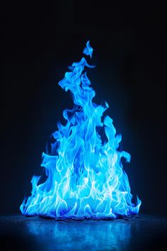 a blue fire is lit up in the dark with bright blue flames coming out of it