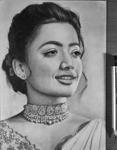 a pencil drawing of a woman with a necklace on her neck, and two pens next to it