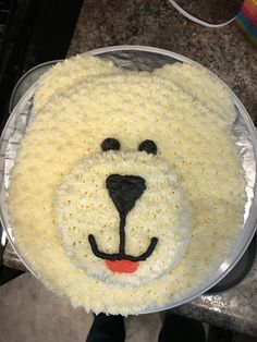 a cake shaped like a polar bear on top of a plastic plate with white frosting
