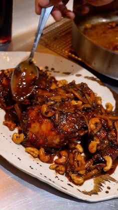 a person is spooning some food on a plate