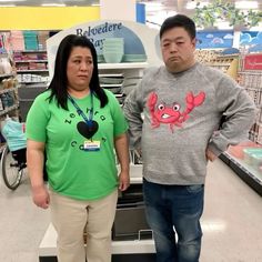 the man and woman are standing next to each other in front of the cash register